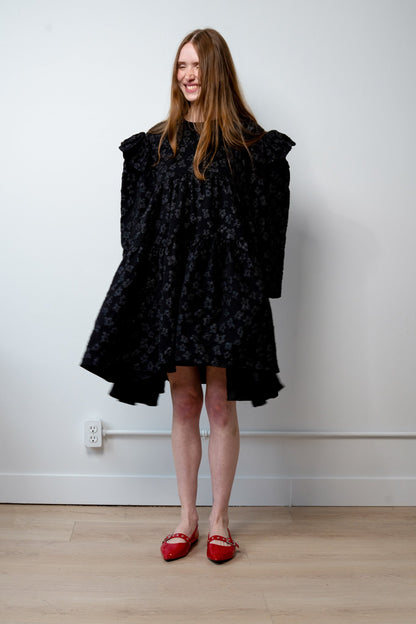 Tatum jacquard dress in black featuring a structured floral-patterned fabric, high-neck detail, and a voluminous skirt.