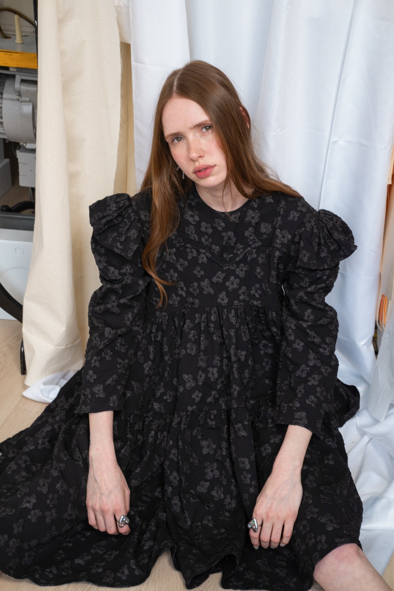 Tatum jacquard dress in black featuring a structured floral-patterned fabric, high-neck detail, and a voluminous skirt.