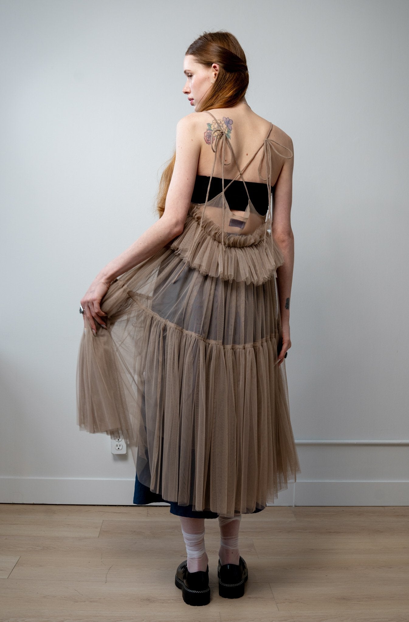 Back view of Georgia tulle dress in a soft beige tone with delicate tiers and a ethereal drape from the core collection.