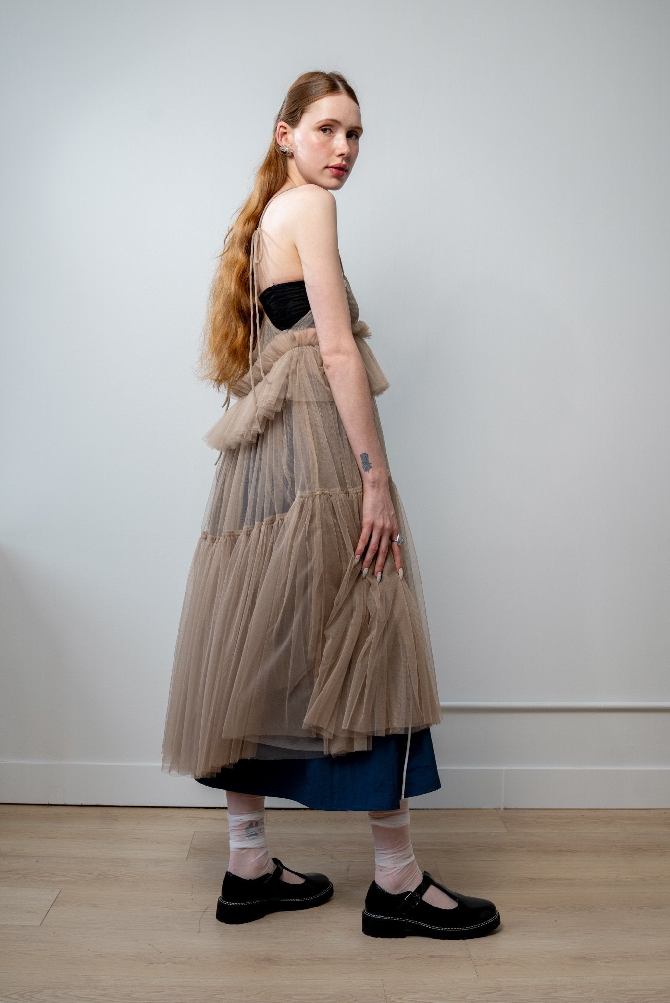 Back view of Georgia tulle dress in a soft beige tone with delicate tiers and a ethereal drape from the core collection.
