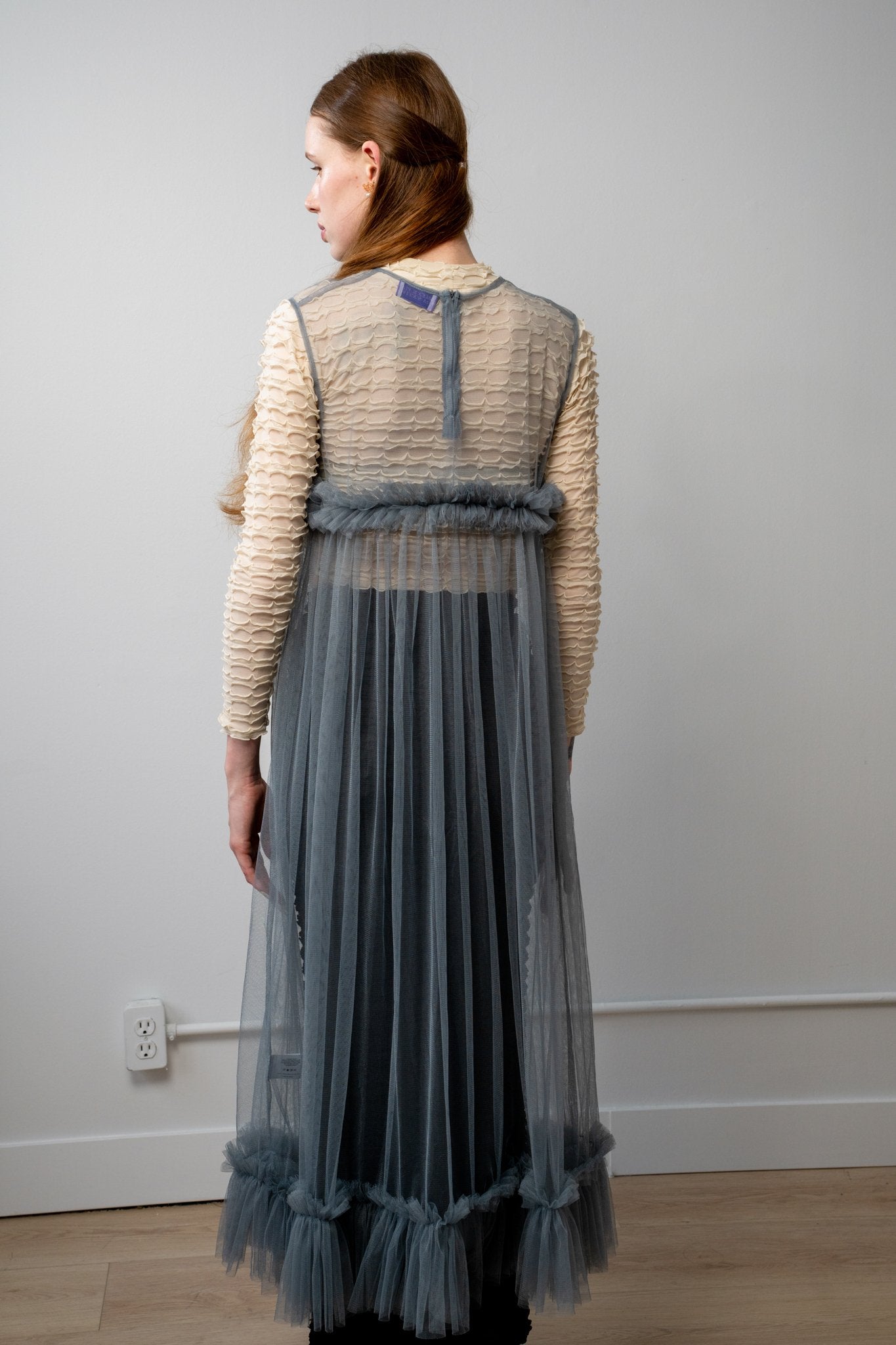 Back of Lula dress in grey showing the midi-length gathered skirt and semi-sheer bodice detailing with a contemporary fit.