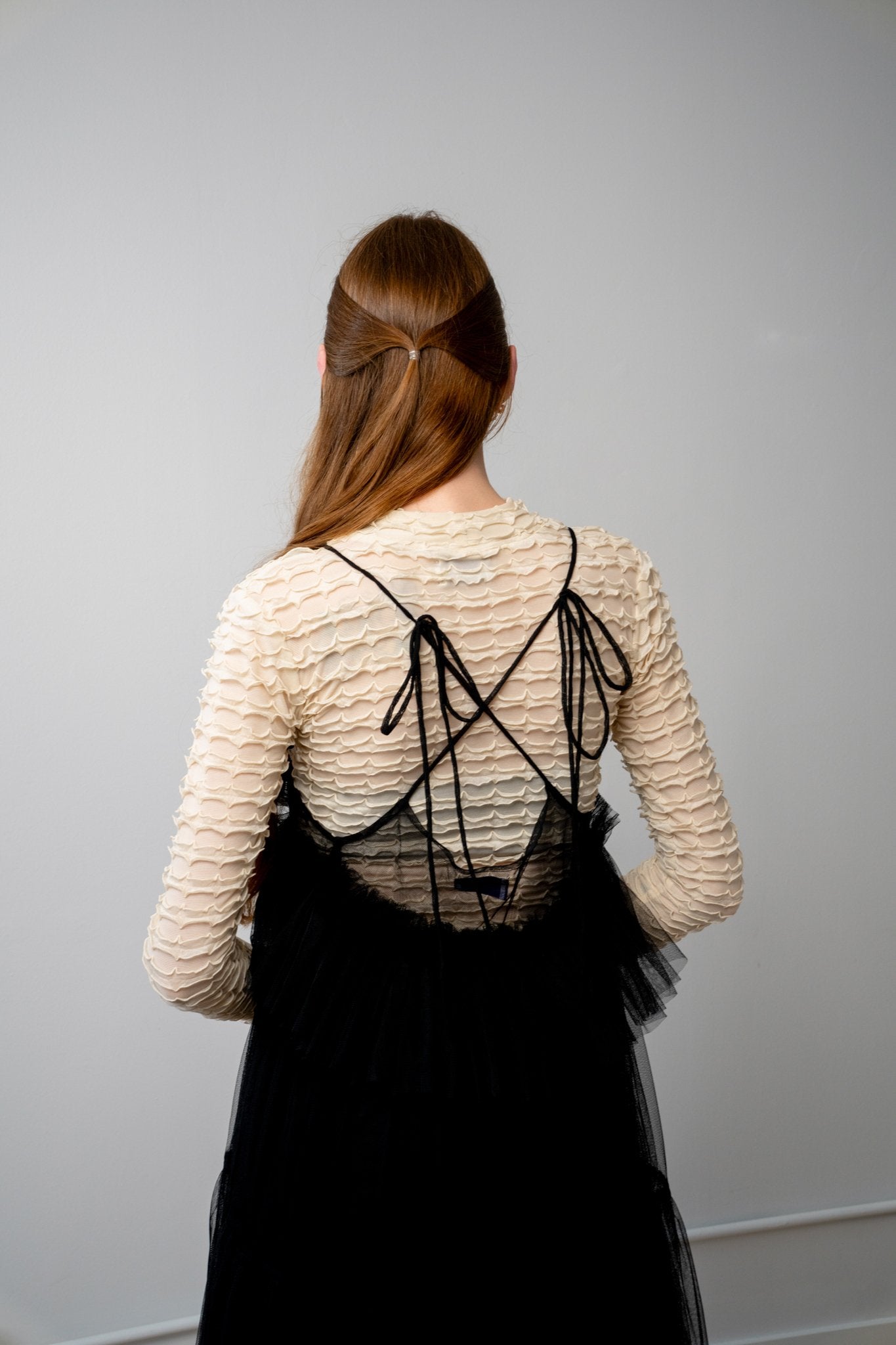 Back view of ALEX S. YU Georgia tulle dress in black featuring a voluminous, tiered silhouette and sheer ruffled layers.