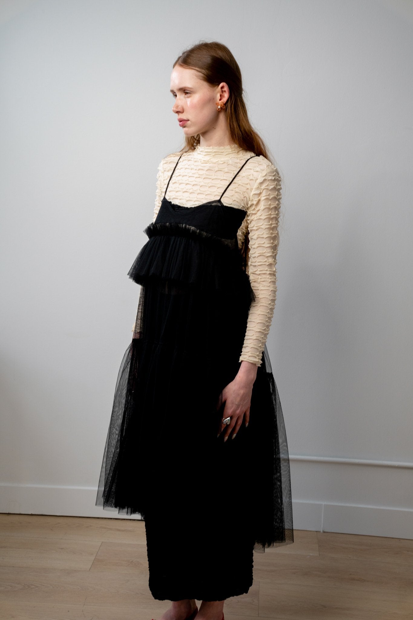 Side view of ALEX S. YU Georgia tulle dress in black featuring a voluminous, tiered silhouette and sheer ruffled layers.