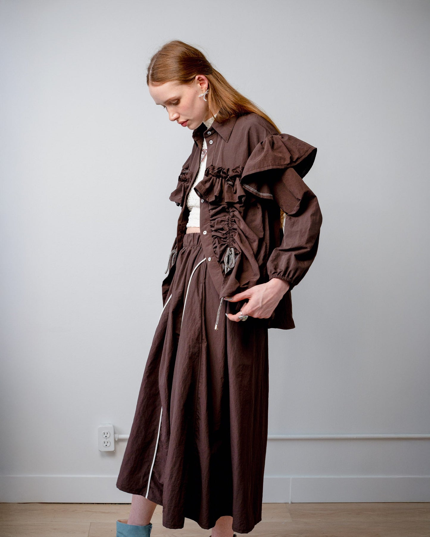 Side view of model wearing the Riley Shirt with the built-in adjustable cords cinched for a fitted silhouette.