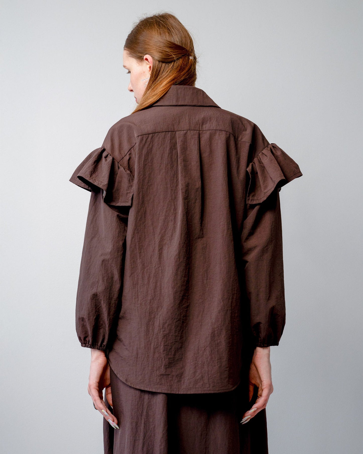 Back view of the whimsical ruffle placement and easy-care nylon fabric on the Riley Shirt.