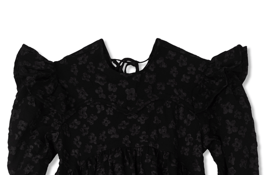 Tatum jacquard dress in black featuring a structured floral-patterned fabric, high-neck detail, and a voluminous skirt.